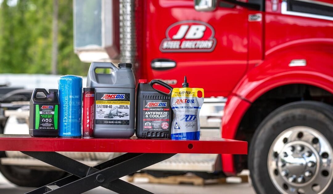Bidons d'huile diesel AMSOIL devant un camion — lecture d'une fiche technique