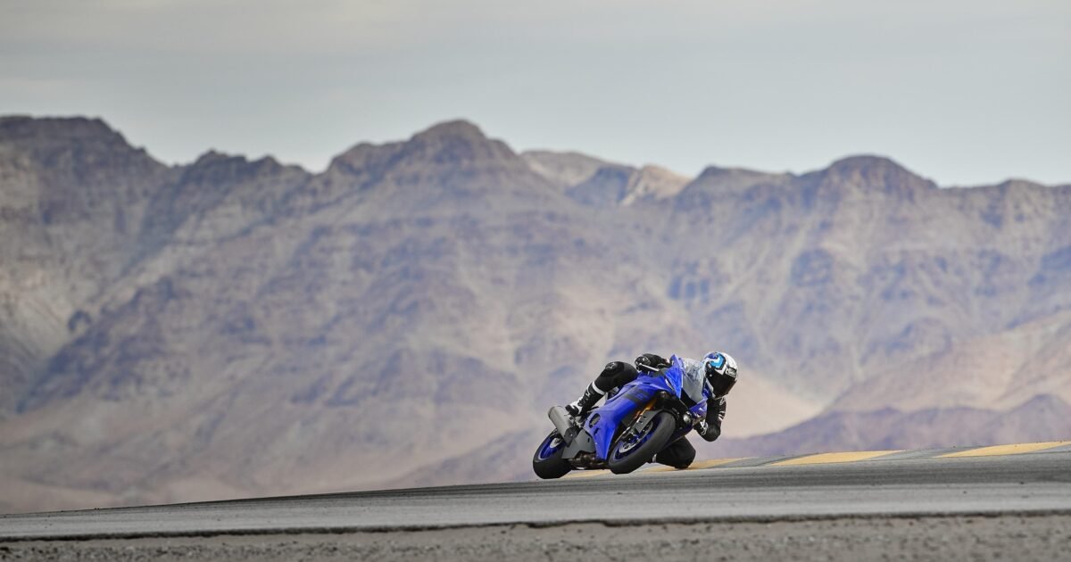 Moto sportive inclinée en virage sur circuit, illustrant les contraintes de haut régime que subit l'huile à moto